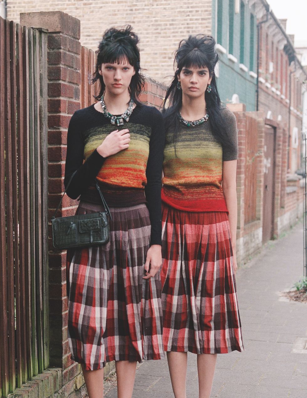 two models standing together in identical outfits and with the same hairstyles