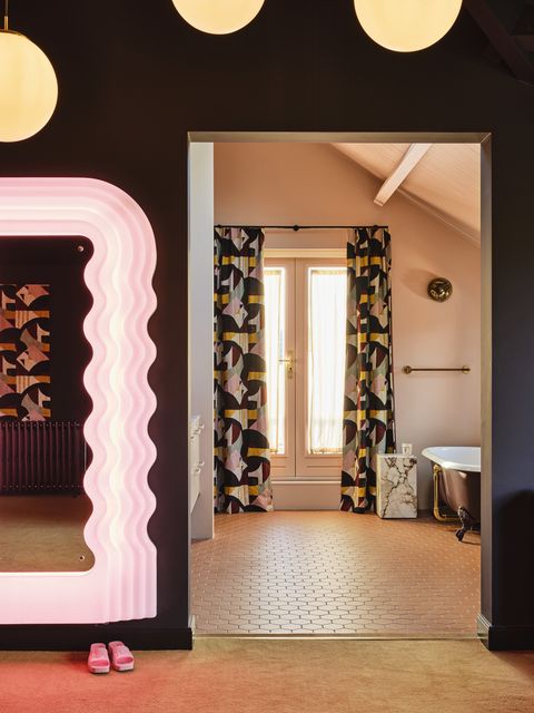 en suite bathroom
matching curtains, an open doorway, and a muted caramel color scheme link the two rooms mirror vintage ettore sottsass tiles winckelmans