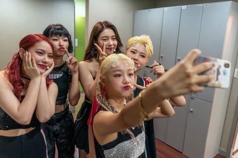 Backstage nemen leden van de Kpopgroep Girls Alert een selfie vr de lancering van hun nieuwe single