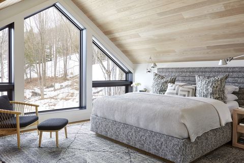 a frame chalet in collingwood, ontario designed by by sarah richardson design and murakami design primary bedroom chair and ottoman design within reach rug elte headboard custom, sarah richardson design, in bilbrough fabric bedding au lit fine linens pillow fabric kravet sconces artemide nightstand serena lily