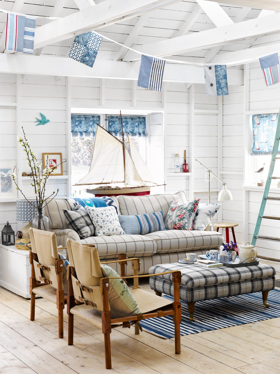 country sitting room with white painted wooden walls and coastal theme