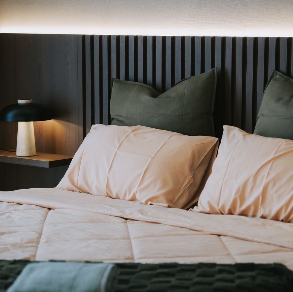 modern cozy bedroom with warm lighting and earth tone bedding