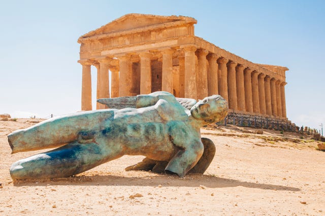 modern sculpture of icarus in front of the temple of concordia, valley of the temples, sicily, italy