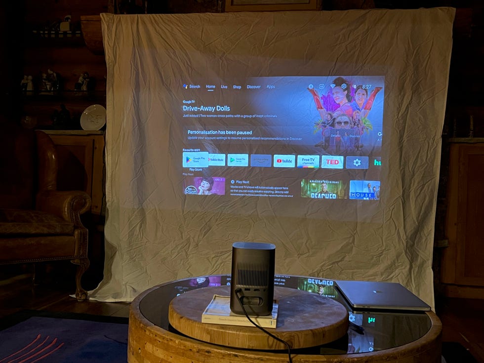 a projector screen with a projector and speakers