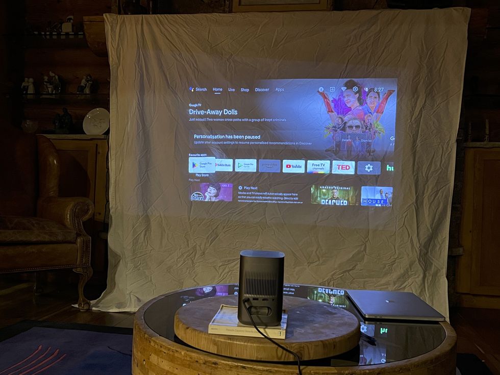 a projector screen with a projector and speakers