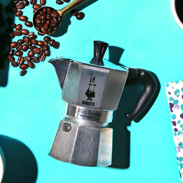 bialetti moka pot with coffee beans and pastry
