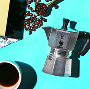 bialetti moka pot with coffee beans and pastry