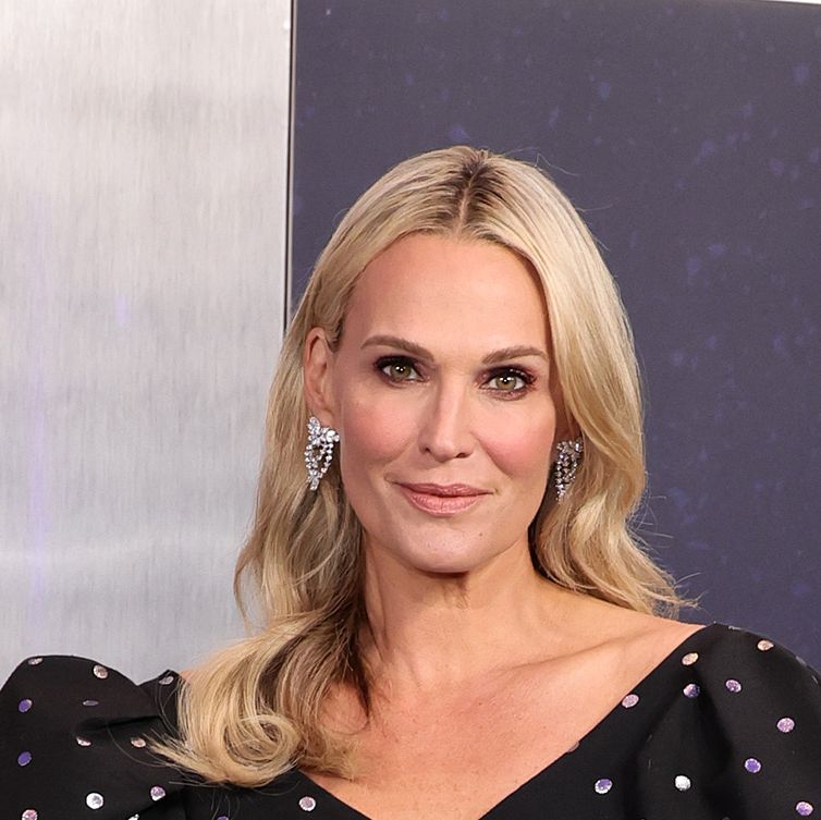 Molly Sims shows off her long legs in a floral swimsuit while enjoying a  cocktail