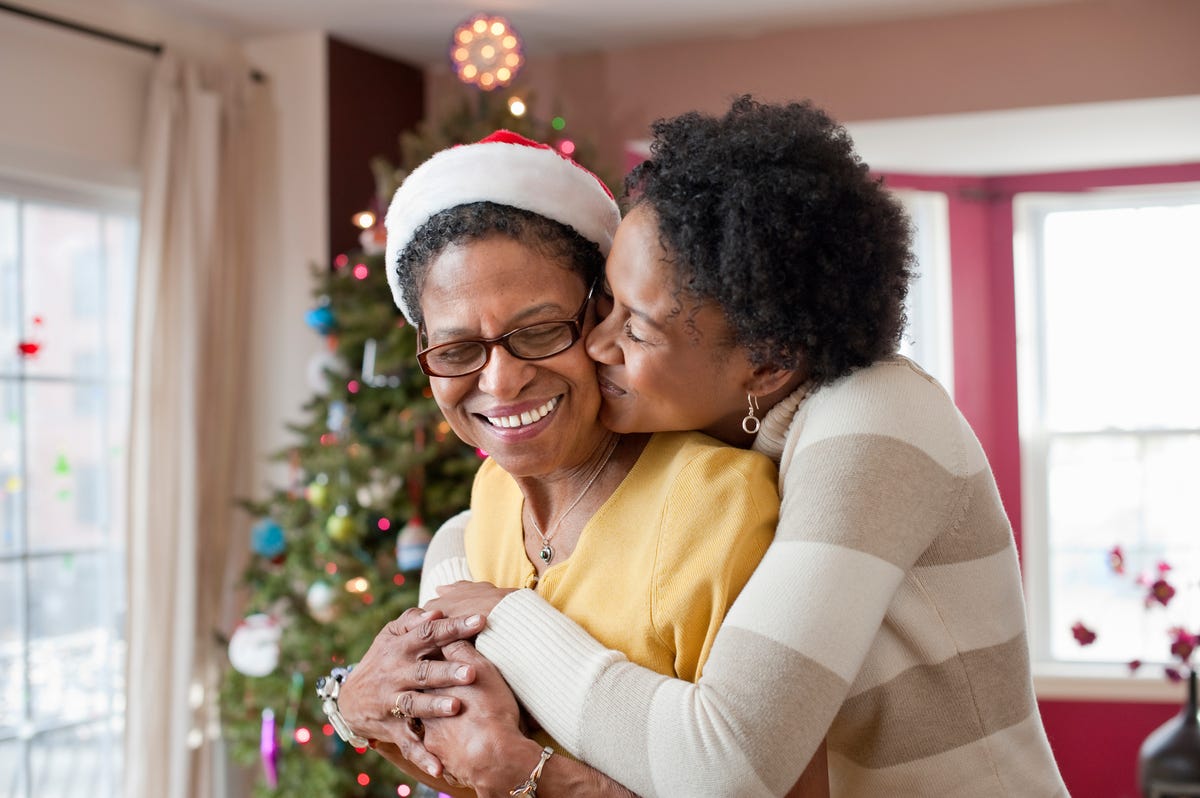 https://hips.hearstapps.com/hmg-prod/images/mom-and-adult-daughter-hugging-at-christmas-tree-royalty-free-image-1666202718.jpg?crop=1xw:0.84554xh;center,top&resize=1200:*