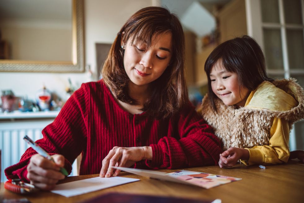 mom daughter preparing greeting card for family at home