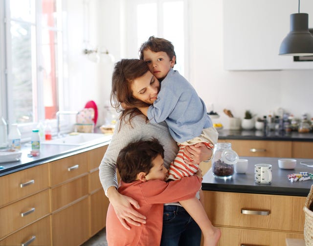 madre con hijos abrazados en la cocina