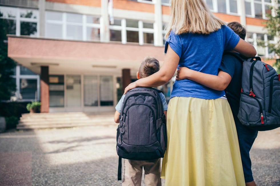 mom hugging sons outside of school