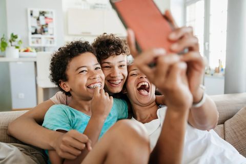 mother and sons laughing and taking a selfie