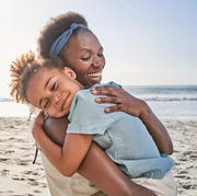 mom hugging daughter on beach mom hugging daughter on beach