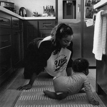 The Entrepreneur Paring Glossy Mules With Cybex mother crawling on floor with baby