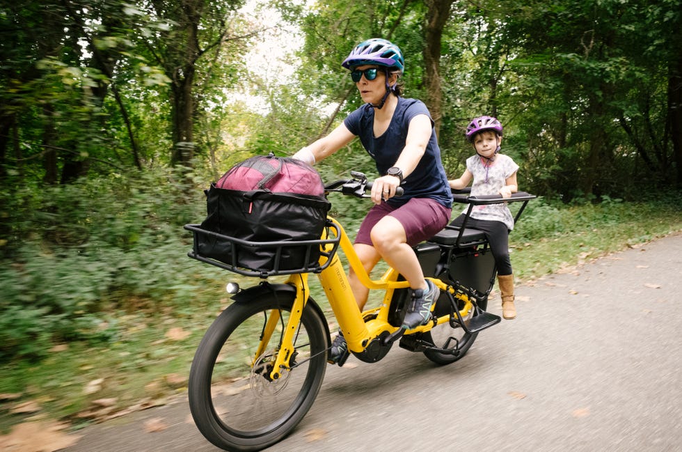 woman and young child riding momentum pakyak e plus cargo bike