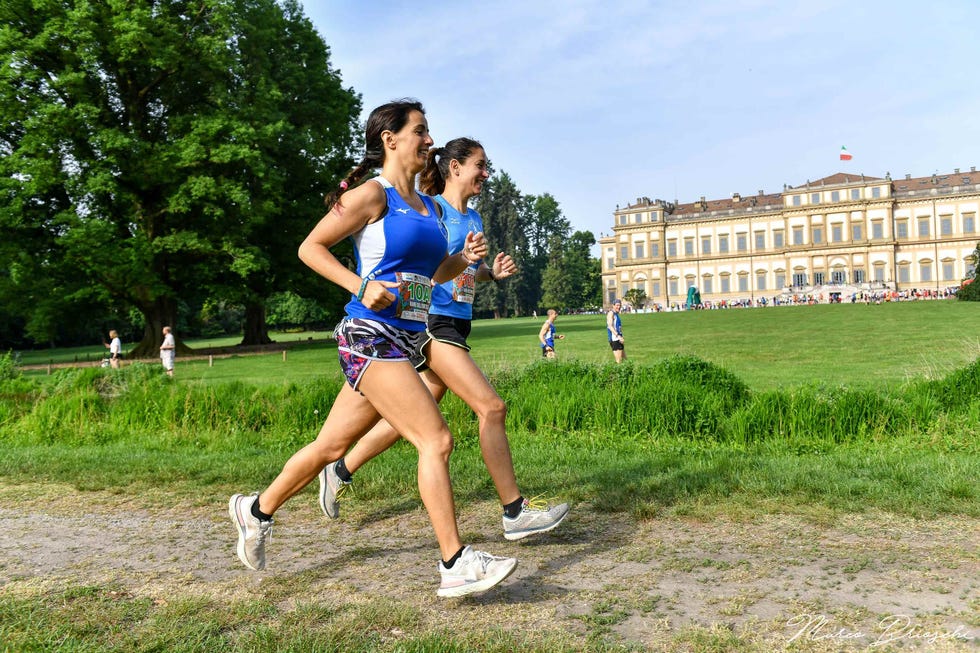 participants running in an outdoor race in front of a large building