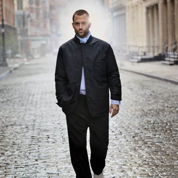 person walking down a wet cobblestone street in an urban setting person walking down a wet cobblestone street in an urban setting