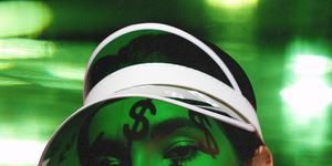 a woman in green light with dollar signs shadowed on her face and dollar bill nail art