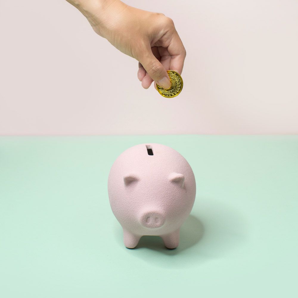 money saving tips   hand putting money in piggy bank