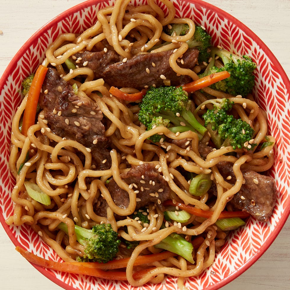 a big bowl of ramen noodles topped with juicy meatballs and broccoli