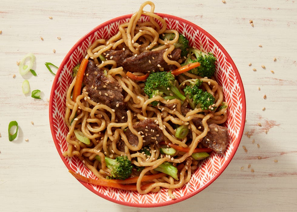 a big bowl of ramen noodles topped with juicy meatballs and broccoli