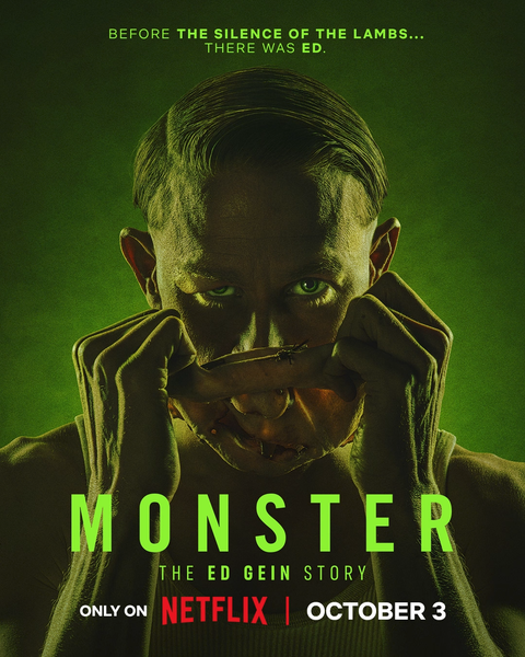 a man with a sinister look pulls up a mask from the bottom of his face as he stares at the camera