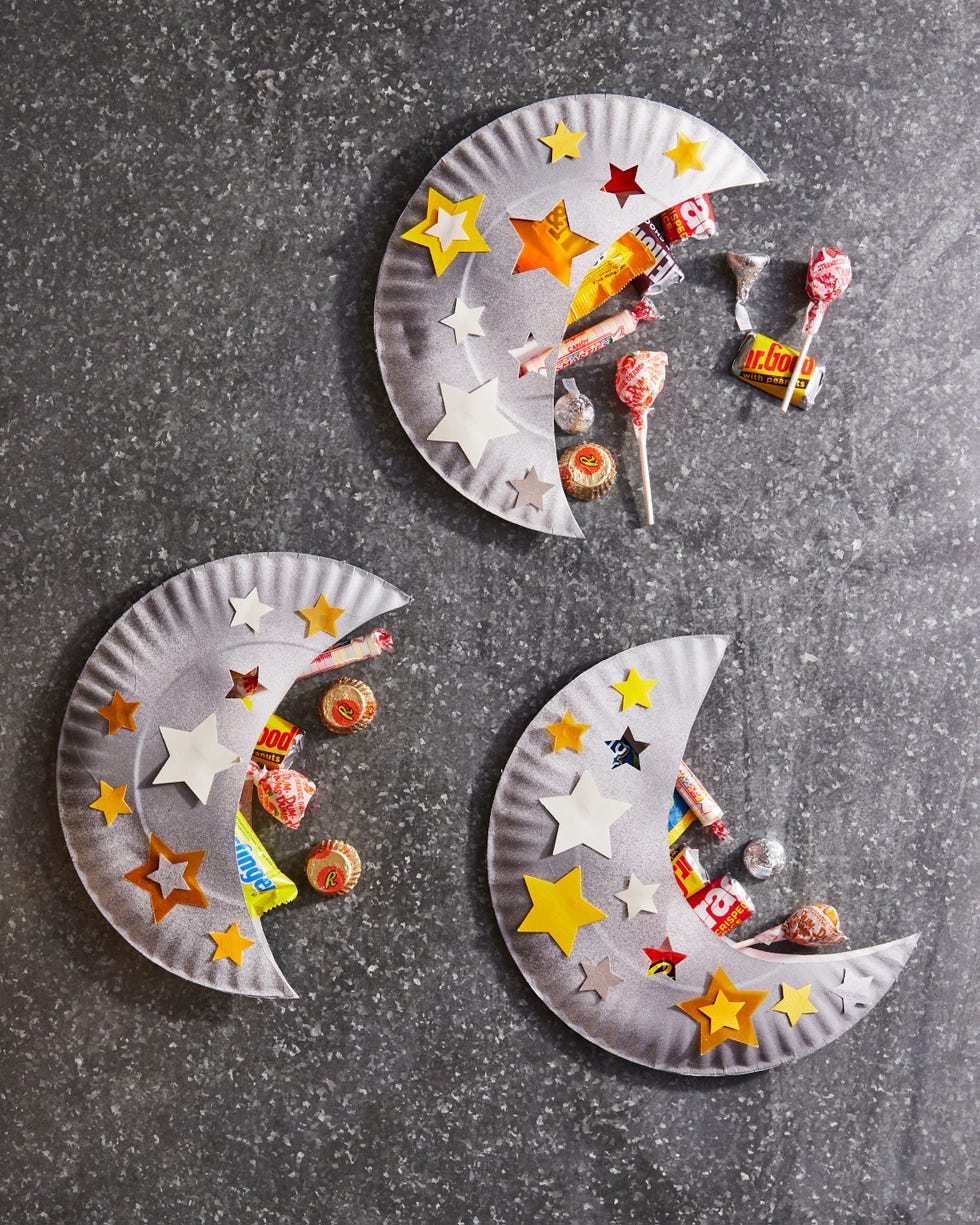 halloween treat holders made from paper plates that have been cut into crescent moon shapes with star shapes cut out of it