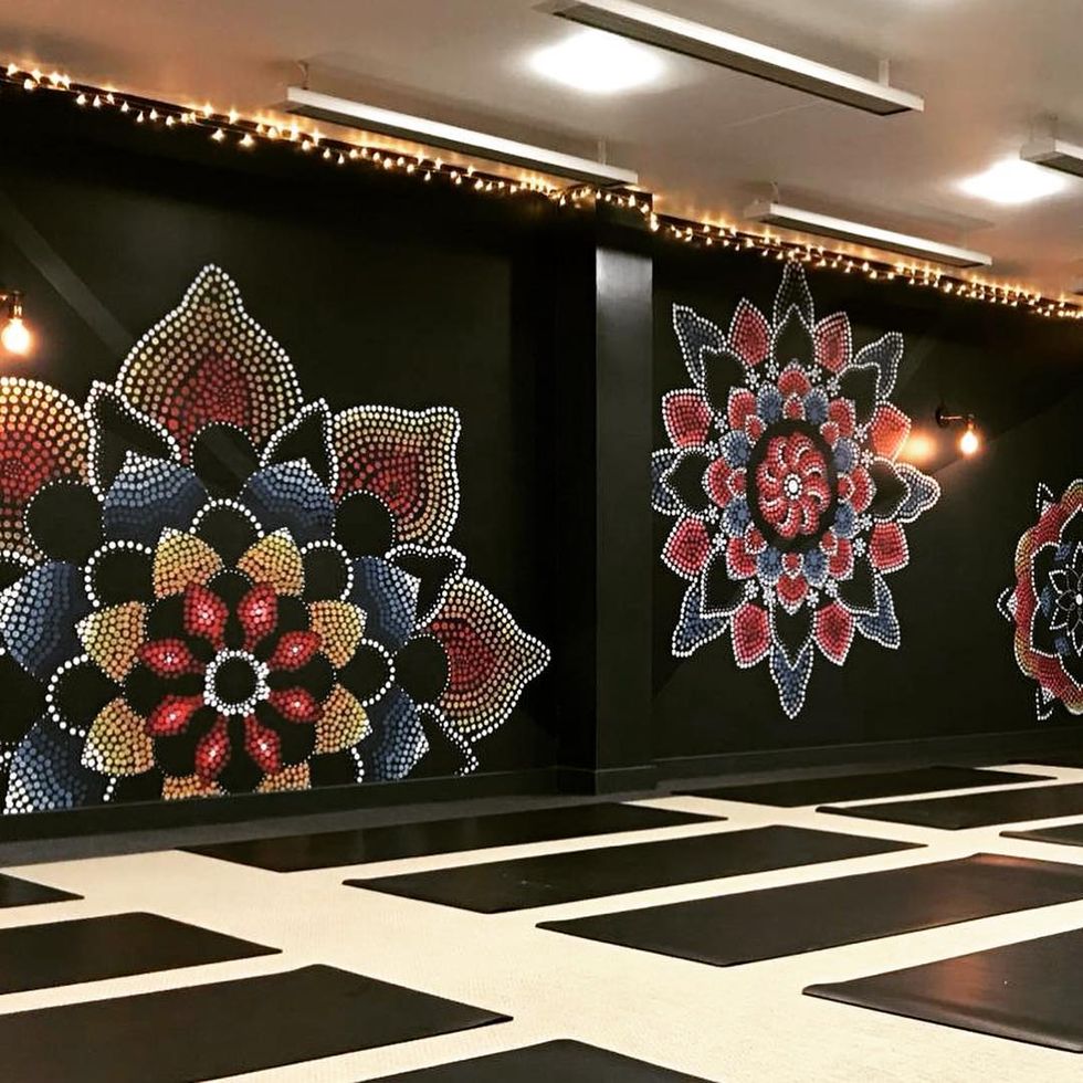 a yoga studio with dark walls featuring mandala patterns
