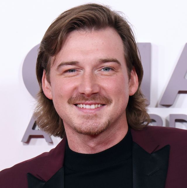 morgan wallen posing for a photo in front of a red carpet backdrop at the cma awards