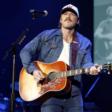 singer standing and playing a guitar on stage