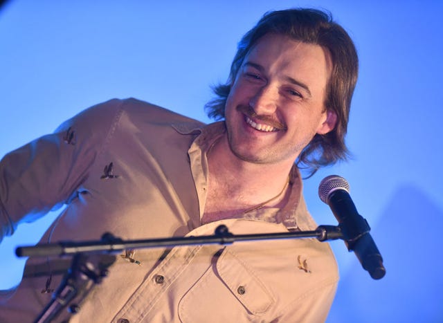 morgan wallen smiling at a microphone