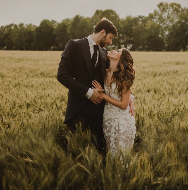 a man and woman kissing in a field of tall grass