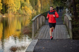 hombre corriendo al lado de un lago