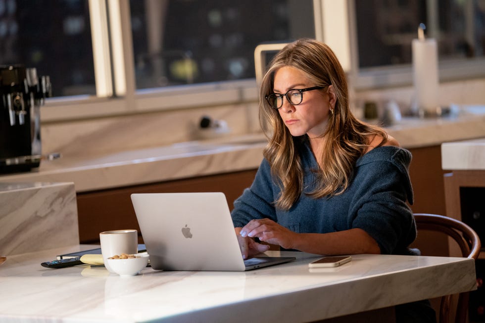 jennifer aniston, as alex, types at her computer in a scene from the morning show season 2