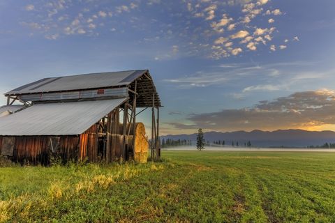 Morning sunrise clouds over hay shed, Whitefish, Montana, USA