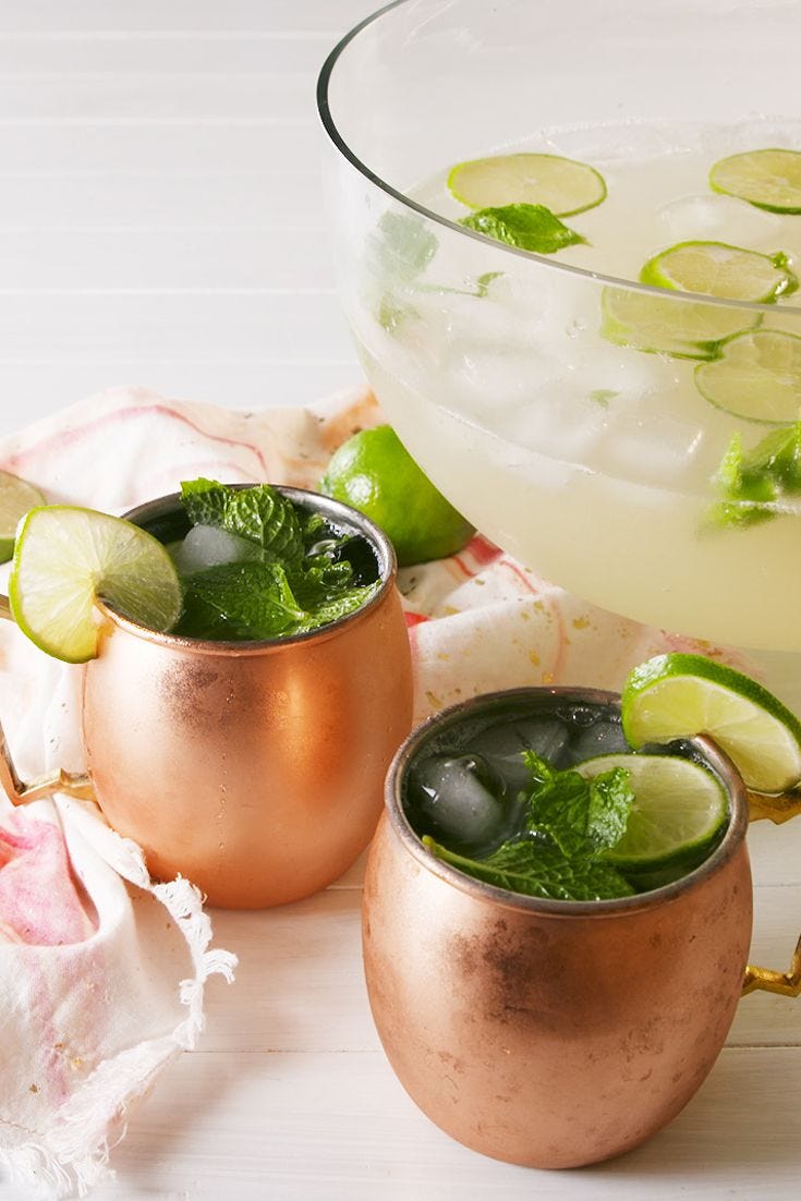 moscow mule punch in copper mugs, garnished with lime and mint