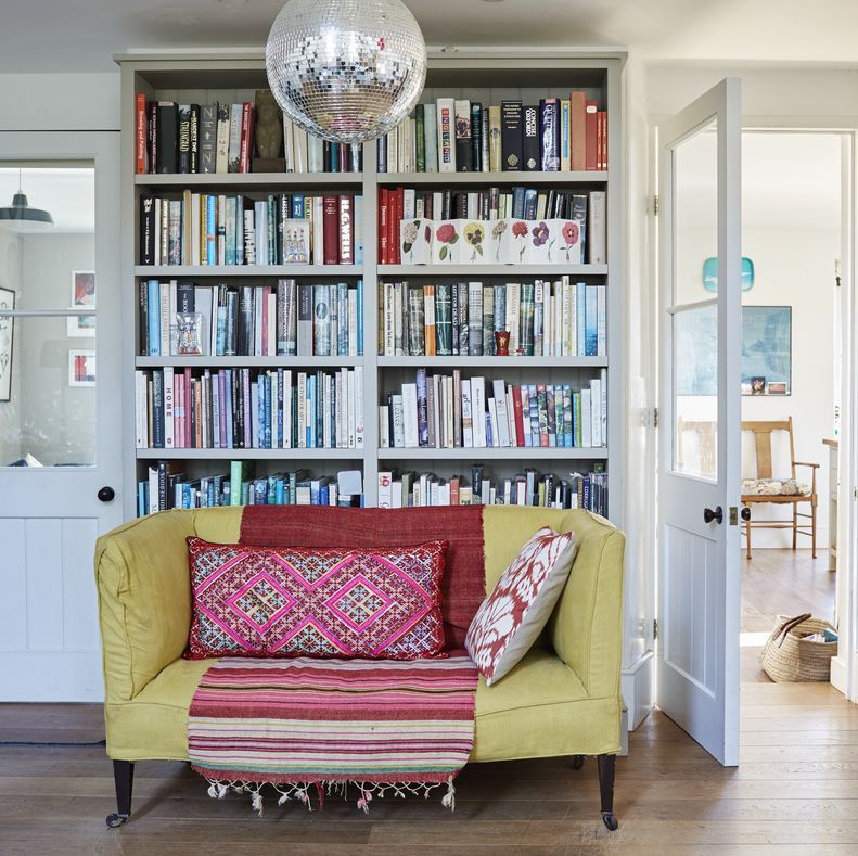 yellow sofa in a living room with bookcase