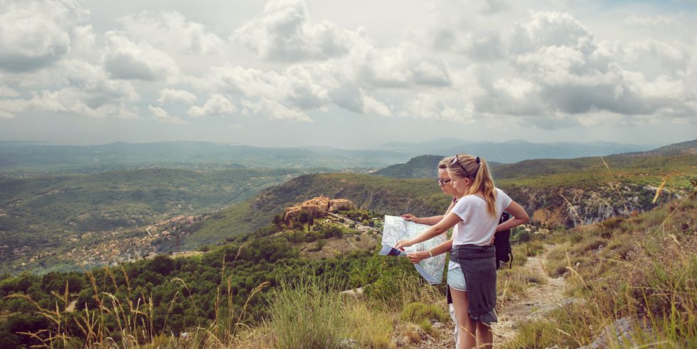 Mother and daugher looking at map in mountains