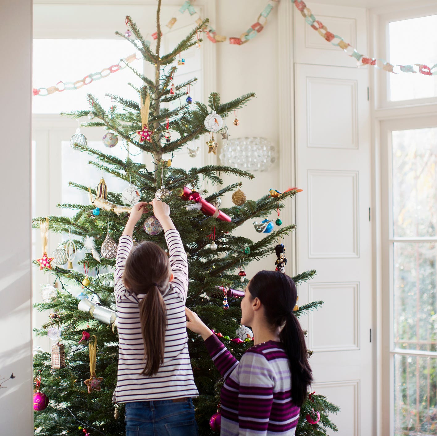 Mother and daughter decorating Christmas tree