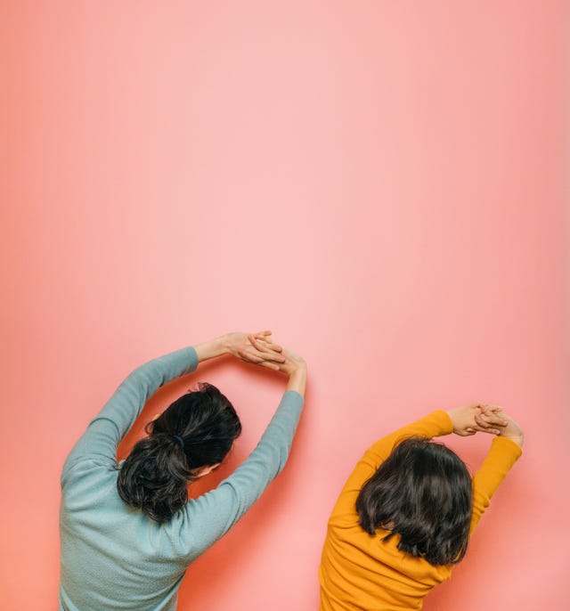 mother and daughter doing stretching together