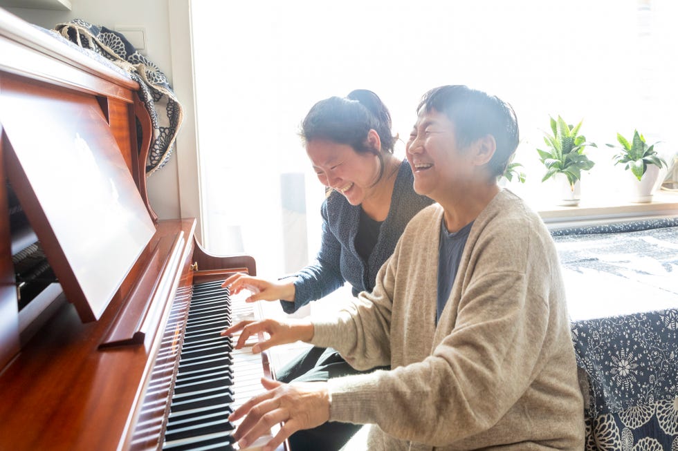 mother and daughter playing piano together