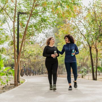 mother and daughter talking and walking through the public park