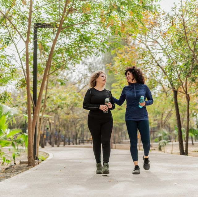 mother and daughter talking and walking through the public park