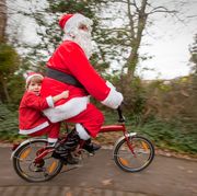 mother and son dressed as santa claus on a bicycle