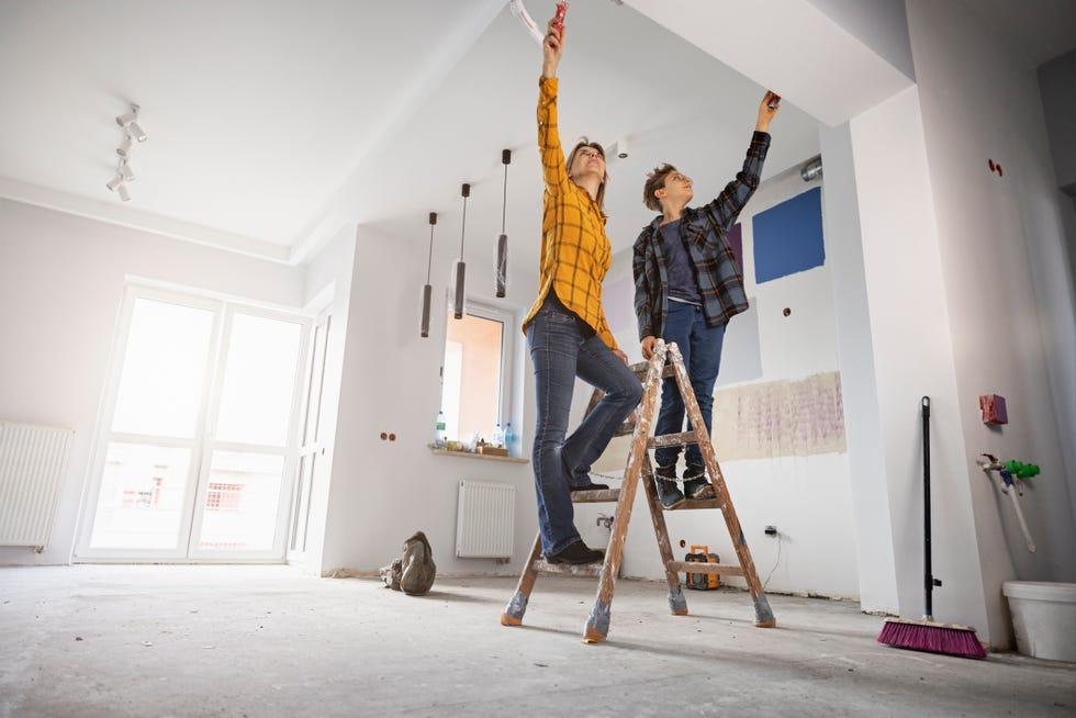 mother and son painting wall at home