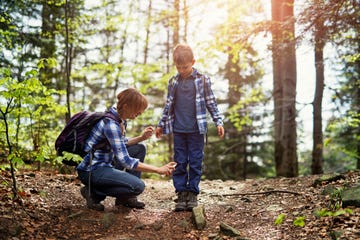 Mother applying tick repellent on son