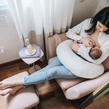 mother breastfeeding her newborn daughter at home