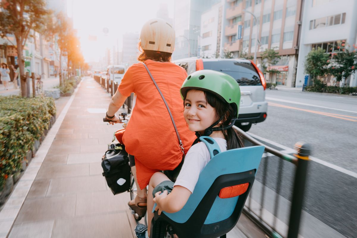 mother cycling home with her preschool child at sunset in tokyo