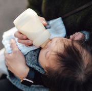 mother feeding baby with bottle outdoor